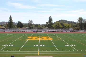 The renovated facilities, including the new gym floor (right) and the improved field came as a result of potential safety hazards to student athletes. [Bailey Cinelli]